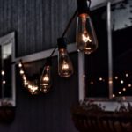 Outdoor Lighting - piled hanging lighted bulb beside house