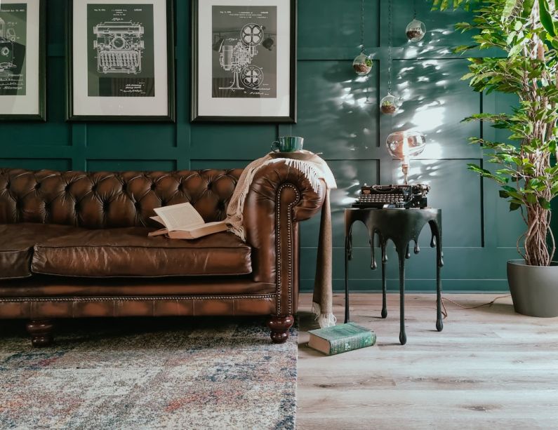 Upcycled Furniture - a living room with a brown leather couch and a potted plant